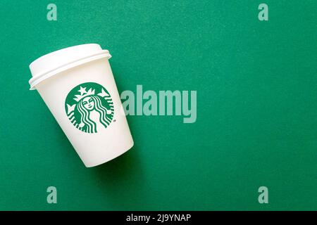 BERLINO - MAGGIO 5: Tazza di carta con logo Starbucks su sfondo verde come piatto con spazio per il testo, vista dall'alto, a Berlino Maggio 05. 2022 in Germania Foto Stock