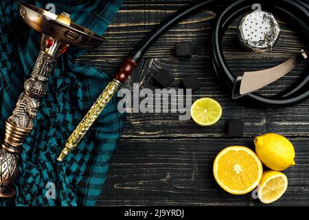 Vista superiore del narghilè con frutta di arancia su uno sfondo di legno Foto Stock