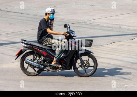 SAMUT PRAKAN, THAILANDIA, 06 2022 MARZO, un uomo che guida una moto e chiama da un telefono cellulare Foto Stock