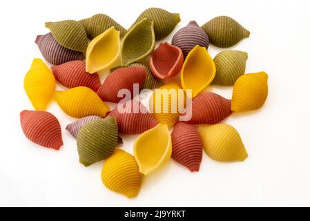 conchiglie colorate, semola italiana di grano duro con curcuma, spinaci, barbabietole e carote nere isolate su bianco Foto Stock