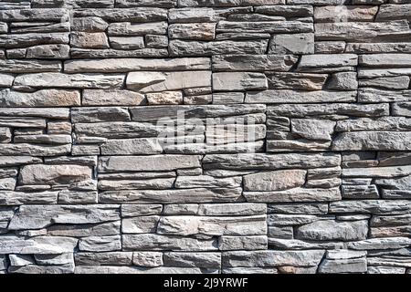 Sfondo fatto di un vecchio muro di pietra grigio naturale Foto Stock