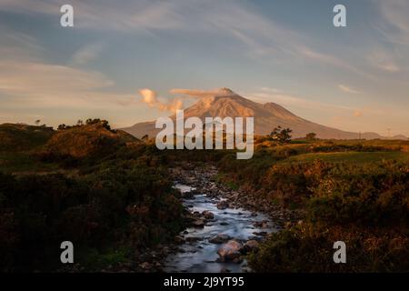 Monte Taranaki e il fiume di pietra al tramonto, Taranak, Nuova Zelanda Foto Stock