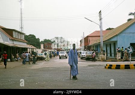 Persone e automobili in strada trafficata del Central Business District, Banjul, Gambia, Africa, 1978 Foto Stock
