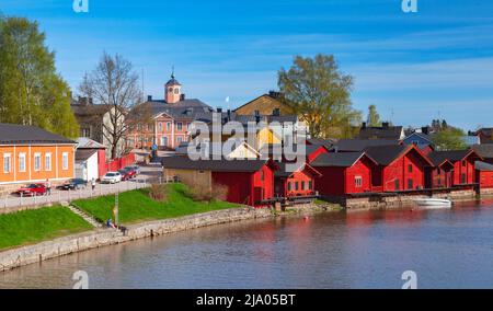 Porvoo, Finlandia - 7 maggio 2016: Paesaggio della città vecchia di Porvoo con case in legno rosso sulla costa del fiume, gente comune cammina per la strada Foto Stock