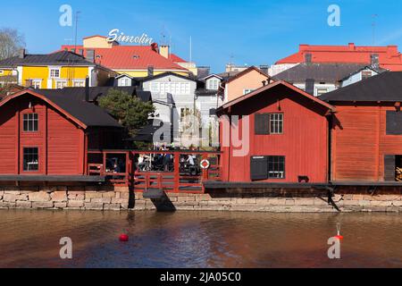 Porvoo, Finlandia - 7 maggio 2016: Vecchie case in legno rosso tradizionale e fienili si trovano lungo la costa del fiume, parte storica della città di Porvoo. I turisti sono o Foto Stock
