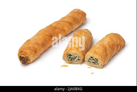 Panini farciti di spinaci turchi e feta appena sfornati interi e dimezzati, chiamati Borek, isolati su sfondo bianco per uno spuntino Foto Stock