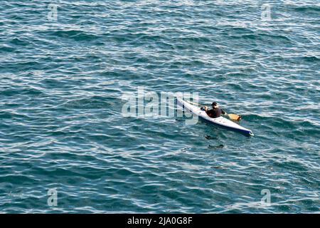 Vista rialzata di un uomo anziano in kayak nel Mar Ligure al largo della costa di Genova, Liguria, Italia Foto Stock