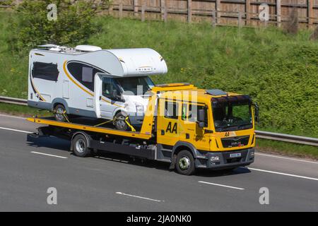 AA 24hr veicolo di recupero stradale che trasporta Tribute Motorhome guidando sulla M61 vicino Manchester, Regno Unito Foto Stock