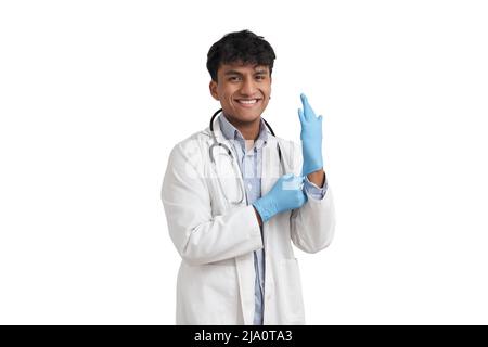 Giovane medico peruviano maschio sorridente e indossare guanti blu, isolato. Foto Stock