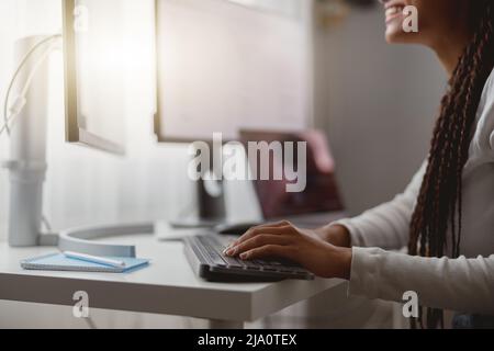 Primo piano di felice giovane donna che lavora al computer, le mani femminili che digitando sulla tastiera Foto Stock