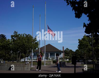 Millbrae, Stati Uniti. 25th maggio 2022. La bandiera degli Stati Uniti vola a metà del personale in una piazza a Millbrae, California, Stati Uniti, 25 maggio 2022. Almeno 19 bambini e due adulti sono stati uccisi in un tiro alla Robb Elementary School nella città di Uvalde, Texas, martedì. Credit: Li Jianguo/Xinhua/Alamy Live News Foto Stock