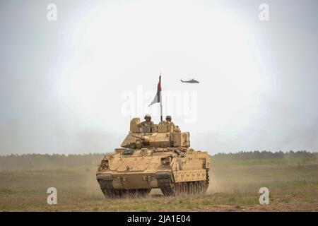 17 maggio 2022 - Drawsko Pomorskie, Polonia - comando militare degli Stati Uniti Sgt. Il Major Kenneth Chaney, il sergente comando maggiore del 3rd Armored Brigade Combat Team, 4th Infantry Division, osserva un esercizio multinazionale sul fuoco a secco di Defender Europe 22 dal suo veicolo M2A3 Bradley Fighting mentre un elicottero polacco MIL mi-24 Hind Attack vola in testa a Drawsko Pomorskie, Polonia, 16 maggio 2022. Defender Europe 22 è una serie di esercizi di addestramento multinazionale dell'Esercito degli Stati Uniti in Europa e Africa che si svolgono nell'Europa dell'Est. L'esercitazione dimostra l'Europa dell'esercito degli Stati Uniti e la capacità di Africaâ di condurre terra su larga scala Foto Stock