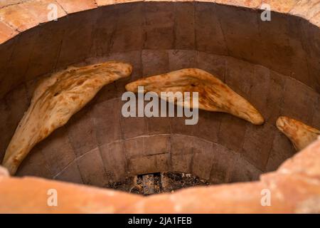 Primo piano di pane georgiano Shoti cotto in un tradizionale forno in mattoni strappato, tandoor Foto Stock