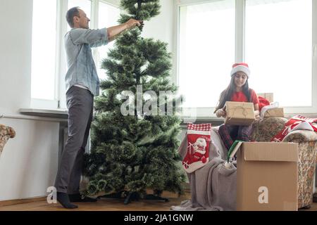 Giovane padre con daugter che adornano l'albero di Natale insieme Foto Stock