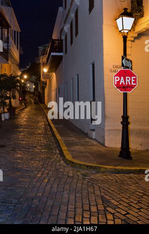 Un segnale di stop rosso brillante contrasta con i toni silenziosi della Vecchia San Juan, Porto Rico di notte Foto Stock