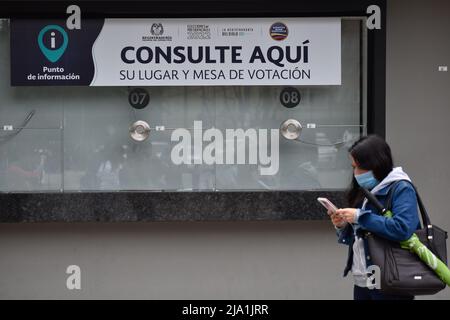 Una persona si trova di fronte a una finestra informativa fissata per le elezioni presidenziali a Bogotà, Colombia, 26 maggio 2022. Le elezioni presidenziali si terranno il 29 maggio. Foto di: Camilo Erasso/Long Visual Press Foto Stock