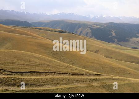 Morbide e belle colline che si affacciano sulle creste innevate alpine sull'altopiano di Assy nei colori autunnali Foto Stock