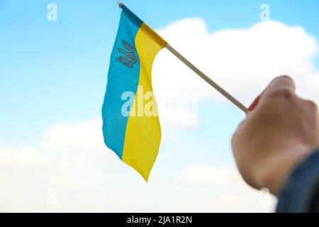 Defocus bandiera Ucraina. Grande simbolo nazionale che sfavillano nel cielo blu. Sostenere e aiutare l'Ucraina, Indipendenza Costituzione giorno, festa nazionale. Mano ho Foto Stock