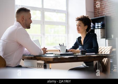 Coppia imprenditrice prendendo un'intervista dell'uomo sulla scrivania di legno in Office Foto Stock