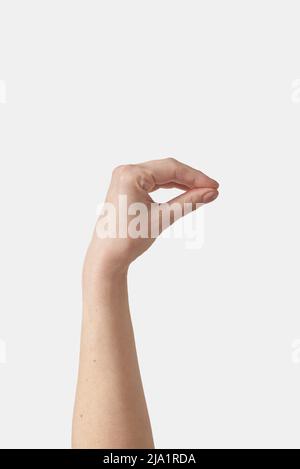 Oggetto invisibile che tiene la mano femminile sul bianco. Foto Stock