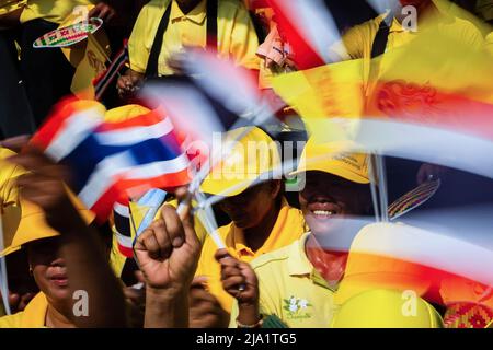 I sostenitori hanno visto sventolare bandiere thailandesi mentre aspettavano la processione reale del re Maha Vajiralongkorn. La gente si schierò per le strade di Bangkok per celebrare l'incoronazione del re Vajiralongkorn che fu incoronato in una cerimonia religiosa più di due anni dopo l'ascesa al trono dopo la morte del padre, re Bhumibol Adulyadej. Foto Stock