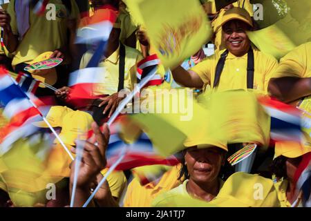 I sostenitori hanno visto sventolare bandiere thailandesi mentre aspettavano la processione reale del re Maha Vajiralongkorn. La gente si schierò per le strade di Bangkok per celebrare l'incoronazione del re Vajiralongkorn che fu incoronato in una cerimonia religiosa più di due anni dopo l'ascesa al trono dopo la morte del padre, re Bhumibol Adulyadej. Foto Stock