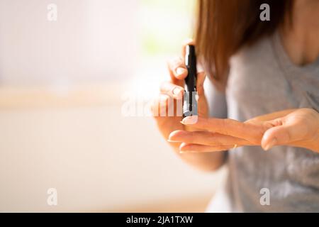 Close-up di una donna test a mano ad alto livello di zucchero nel sangue con il glucometro Foto Stock