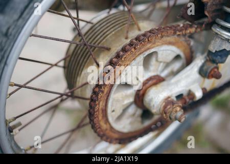 Primo piano di una catena di trasmissione per motociclette arrugginite. Foto Stock