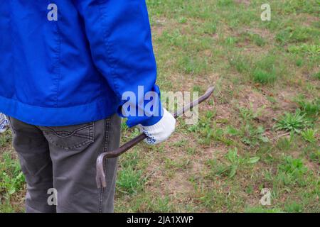 Lavoratore in tute blu con leva in ferro all'aperto, spazio copia. Riparazione e servizi del comandante. Foto Stock