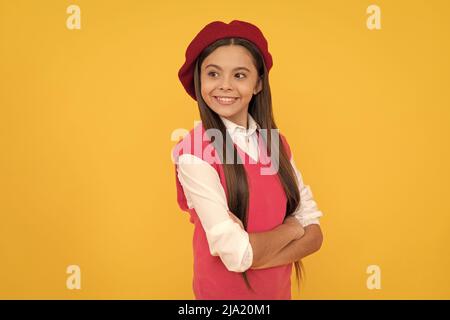 felice teen scuola ragazza in beret francese su sfondo giallo, sorriso Foto Stock