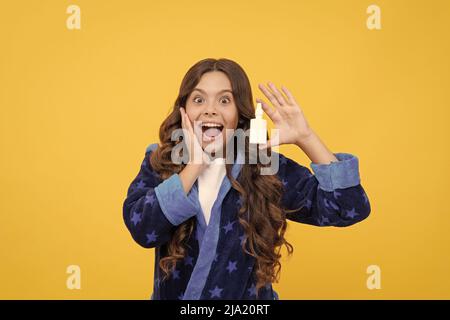 sorprende ragazza di capretto nel sonnwear usando spray nasale contro naso chiuso, medico Foto Stock