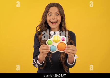 stupito teen girl giocare con pop o semplice fidget giocattolo sensoriale silicone fossile, dimpl semplice Foto Stock