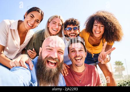 Gruppo allegro di ragazzi e ragazze in posa per una foto selfie e divertirsi. Amicizia e concetto di comunità Foto Stock