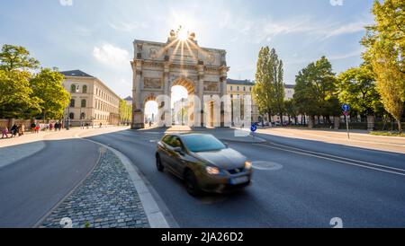 Sun Star, Siegestor, Car drive lungo Leopoldstrasse, architettura neoclassica, Baviera, Monaco, Baviera, Germania Foto Stock