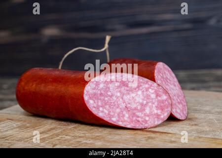 salsiccia a fette con carne, pancetta e altri prodotti alimentari durante la preparazione di sandwich, preparare sandwich a casa Foto Stock