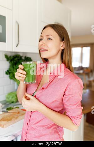 Pasto sano. Felice bella donna sorridente che beve verde Detox vegetale Smoothie. Stile di vita sano, cibo e mangiare. Bere succo. Dieta, salute e bellezza concetto. Foto Stock