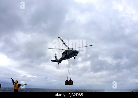 220521-o-NR876-691 PHILIPPINE SEA (21 maggio 2022) un elicottero MH-60s Seahawk, assegnato a Helicopter Sea Combat Squadron (HSC) 21, distaccamento 8, solleva dal ponte di volo della nave da combattimento litoranea di classe Independence USS Charleston (LCS 18) con pallet di forniture da trasportare al cacciatorpediniere di classe Arleigh Burke USS Sampson (DDG 102). Charleston, parte di Destroyer Squadron (DESRON) 7, è in fase di implementazione rotazionale, operando nell'area operativa della flotta USA 7th per migliorare l'interoperabilità con i partner e fungere da forza di risposta pronta a supporto di un ID libero e aperto Foto Stock