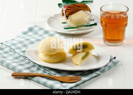 Bakpia Kukus Jogja o Bakpia Tugu, torta rotonda al vapore con pasta di fagioli mung all'interno. Su tavola bianca Foto Stock