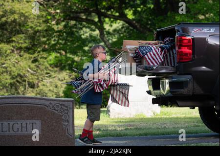 Dallas, Stati Uniti. 25th maggio 2022. Un cub scout restituisce le bandiere ritirate su un camion mentre le sostituisce con nuove per la festa del Memorial Day. I membri della Legione americana, dei Boy Scouts e dei Girl Scouts hanno sostituito le bandiere tattered in tutti i cimiteri in preparazione alla festa del Memorial Day. (Foto di Aimee Dilger/SOPA Images/Sipa USA) Credit: Sipa USA/Alamy Live News Foto Stock