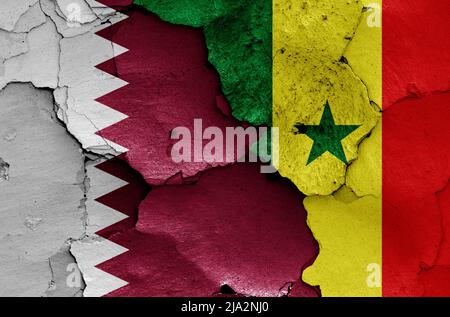 Bandiere del Qatar e del Senegal dipinte su muro rotto Foto Stock