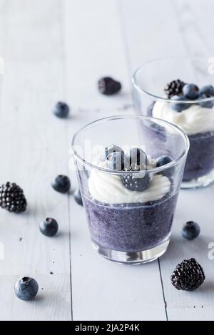 Parfait di budino al mirtillo chia con yogurt alla vaniglia e bacche. Foto Stock