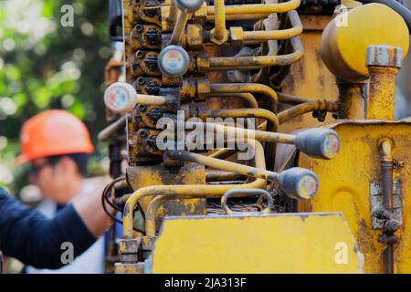 Macchina idraulica a gru di controllo ingegneristico a mano. Primo piano delle vecchie leve per il controllo delle attrezzature da costruzione mobili. Carrello gru di controllo Foto Stock