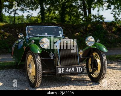 Collonges-la-Rouge, Francia - 13 maggio, 2022: Primo piano di una storica Morgan a tre ruote restaurata nel verde delle corse britanniche Foto Stock