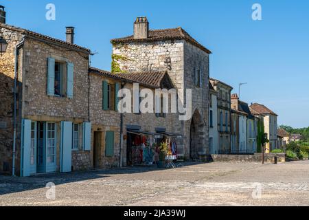 Monpazier, Francia - 11 maggio 2022: Edifici delle mura esterne e porta della città nel centro storico di Monpazier Foto Stock