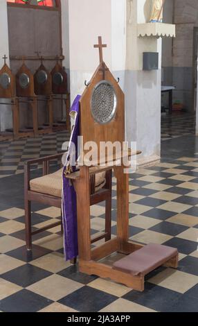 Una sedia confessionale e panca di ginocchio all'interno di una chiesa nel sud dell'India. Foto Stock