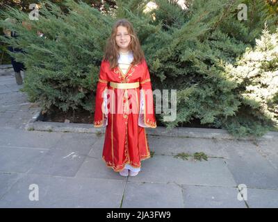 ragazza turca dagli occhi blu con capelli ondulati in un abito folcloristico Foto Stock