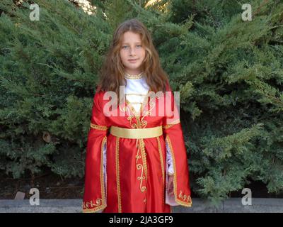 ragazza turca dagli occhi blu con capelli ondulati in un abito folcloristico Foto Stock