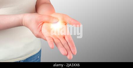 dolore al polso. Sindrome del tunnel carpale, artrite, concetto di malattia neurologica. Intorpidimento della mano. Primo piano di vista della giovane donna con dolore a portata di mano sul grigio b Foto Stock