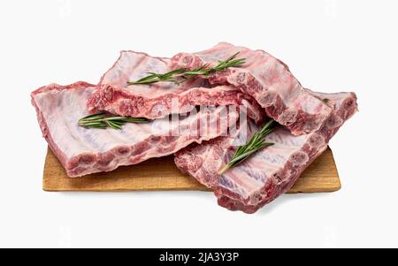 Costolette di maiale crudo. Costolette di maiale crude intere su tavola di legno fondo isolato. Carne cruda, fattoria e concetto di cucina. Negozio di carne. Rack di carne di maiale crudo fresco ri Foto Stock