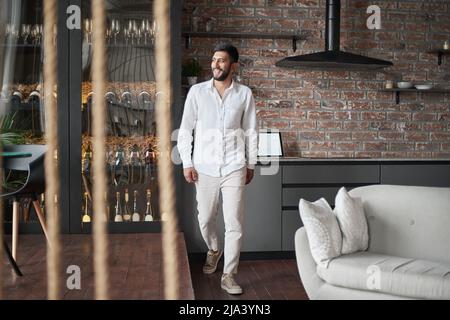 giovane uomo che cammina attraverso la sala di un negozio di liquori . Foto Stock